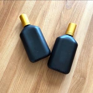 TWO EMPTY BLACK VANITY BOTTLES GOLD CAP